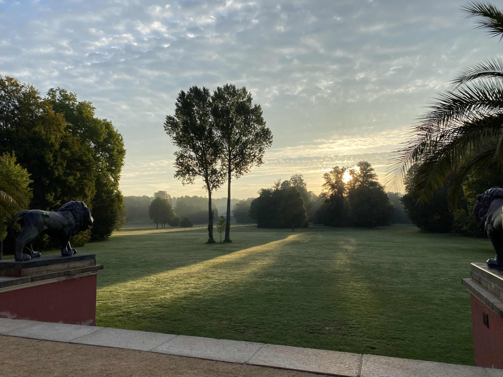 Der Blick von der Schlossrampe auf die Schlosswiese vorbei an den L&ouml;wenskulpturen